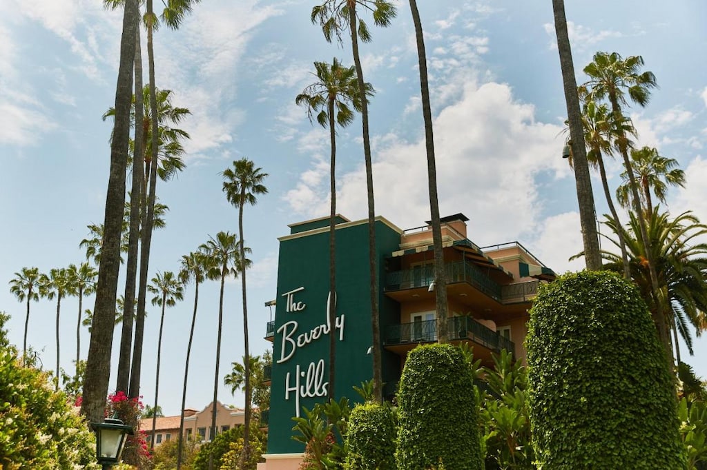 The Beverly Hills Hotel with green wall and white writing and palm trees