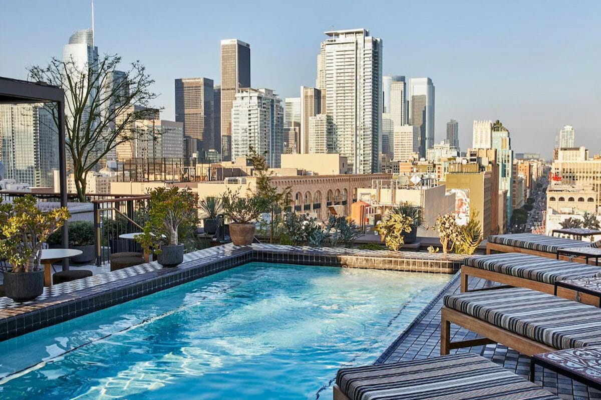 cool Boutique hotel in Downtown Los Angeles rooftop pool with loungers overlooking tall buildings