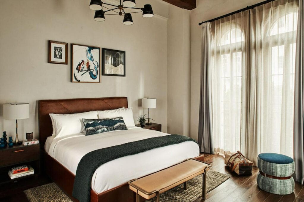 LA hotel room adorned with sophisticated historic Spanish decor with large bed and sitting bench