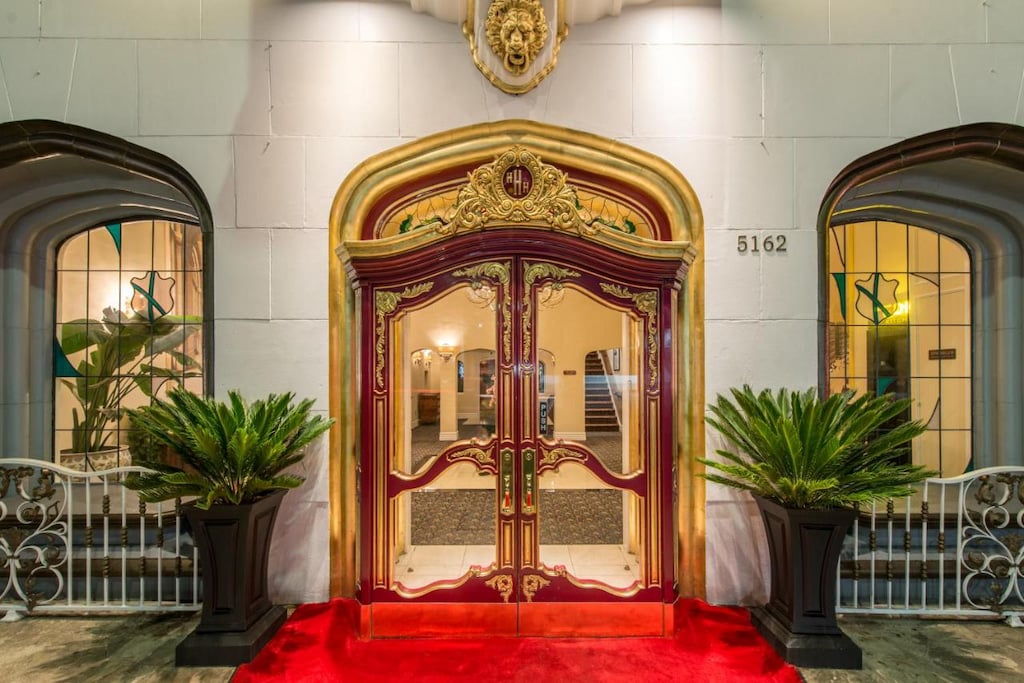 The facade of the Hollywood Historic Hotel with ornate gold and red door frame and red carpet