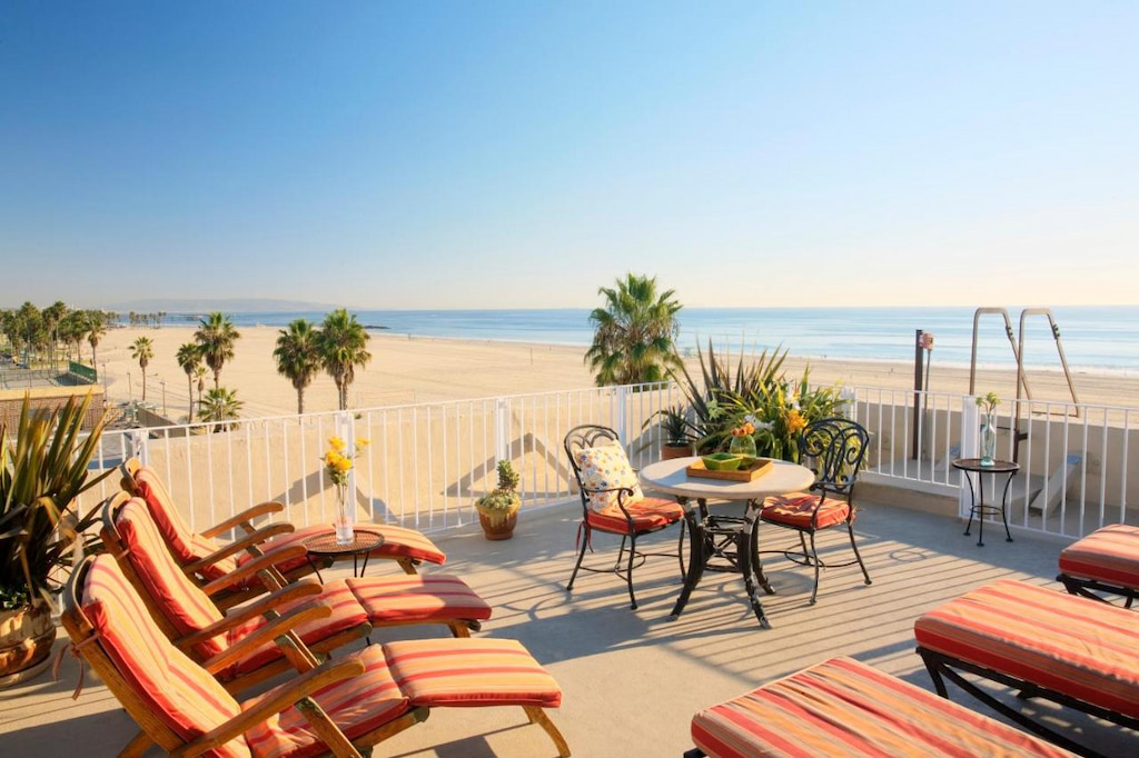 A outdoor patio with orange sun loungers with an amazing view of the ocean and Venice Beach