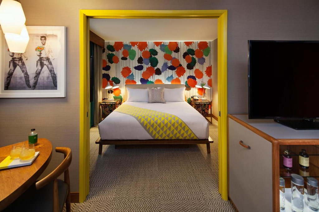 Venice Beach CA hotel with yellow door trim and colorful feature wall with bed