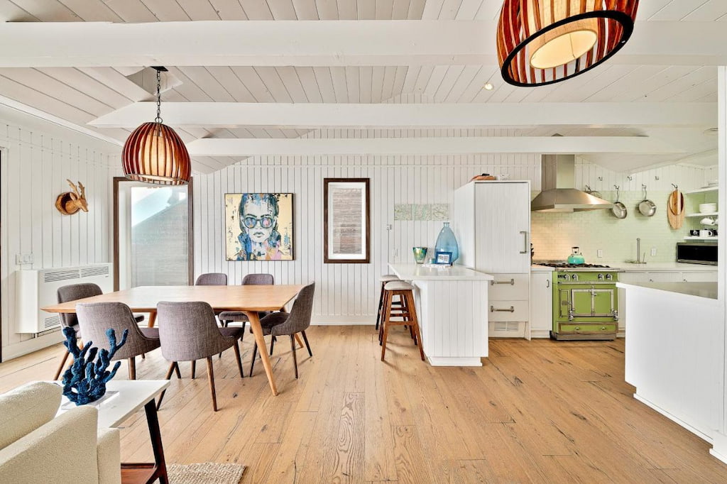 A chic hotel in Malibu CA with a dining table near the fully functioning kitchen.