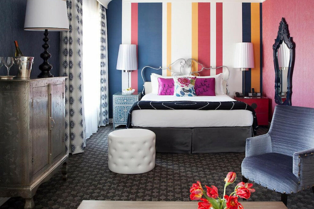 five star hotel in San Francisco with a striped-wall design and white stool chair near the bed