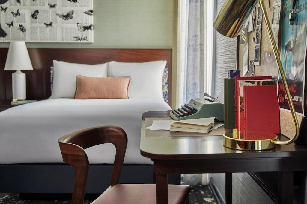 boutique hotel room with study table, gold reading lamp and chair near the comfortable bed in San Francisco, California