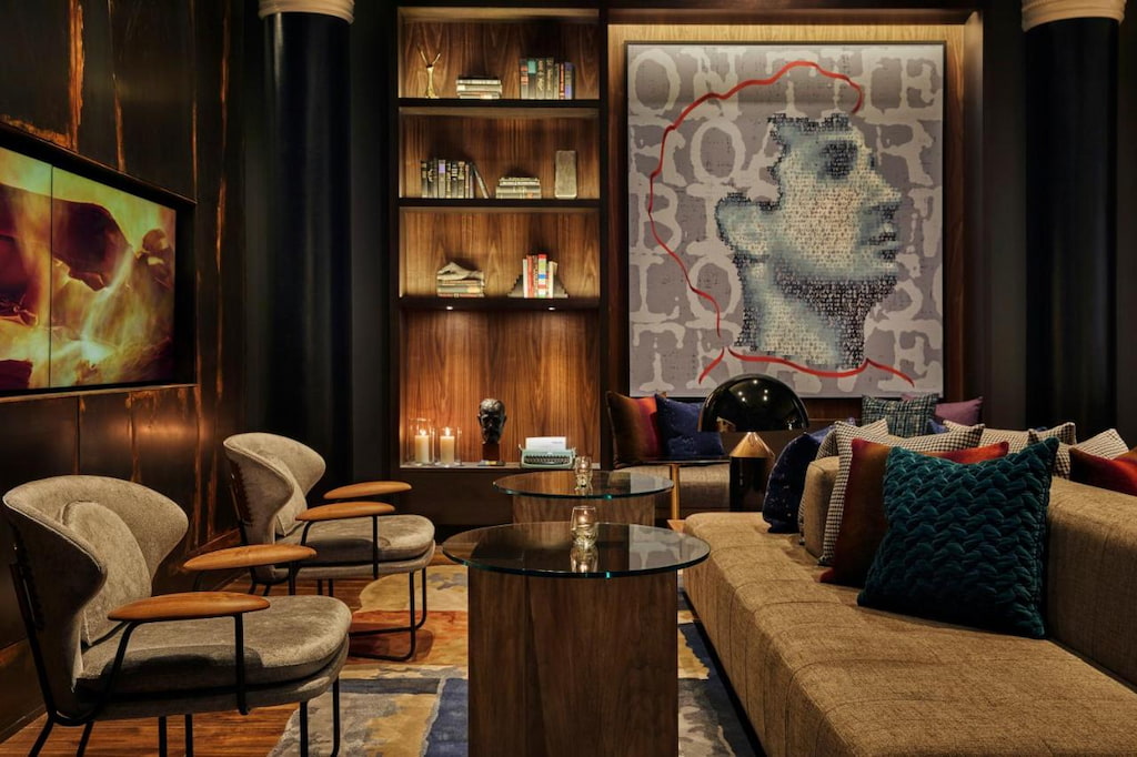 boutique Hotel san francisco lobby lounge with long light grey couch in front of accent chairs with two glass tables in the middle and large art on the back wall