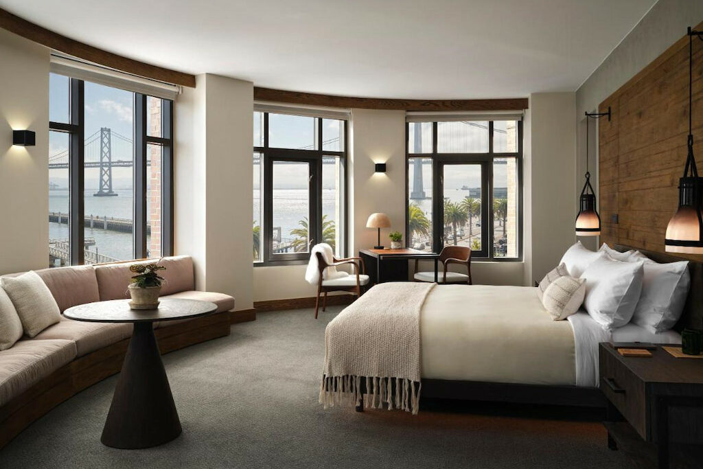 cool boutique San Francisco hotel with a perfect view of the bridge from the window and earthy bed, couch, table and desk