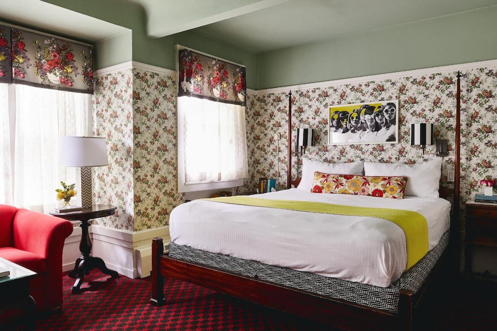 Floral-themed room with a king-size bed near the red sofa by the window