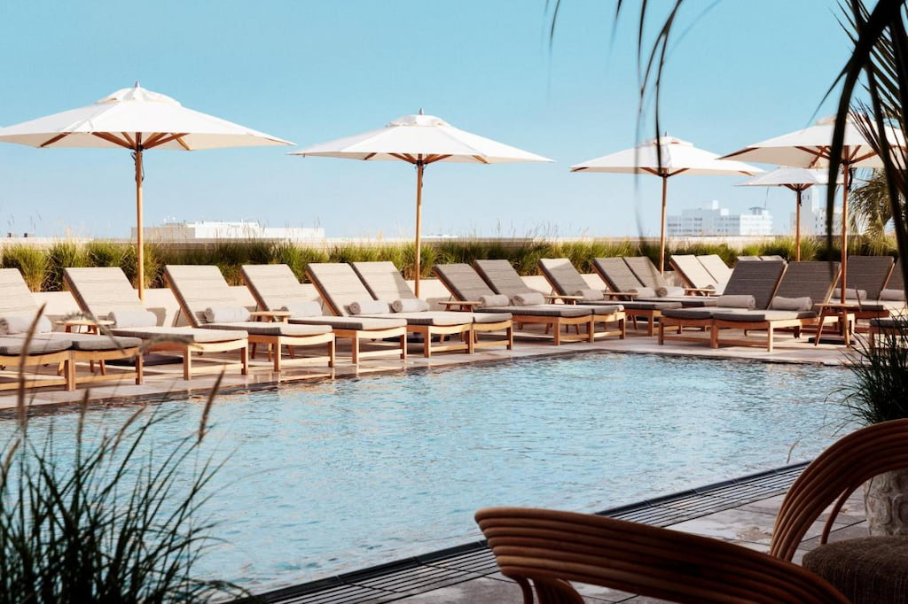 characteristics of a boutique hotel means beautiful rooftop pools with sun loungers and white umbrellas on a sunny day