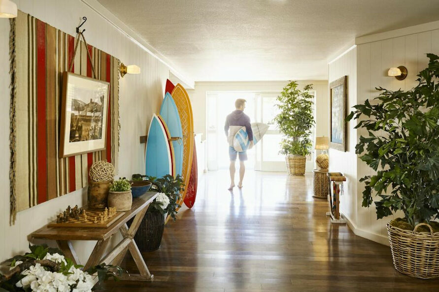 one of the Laguna Beach boutique hotels   in California with surfboard decor in its main hallway with man in the distance