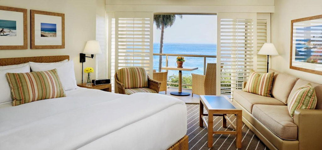 oceanfront hotels in  Laguna Beach with light and bright furnishings, white bed and shuttered windows