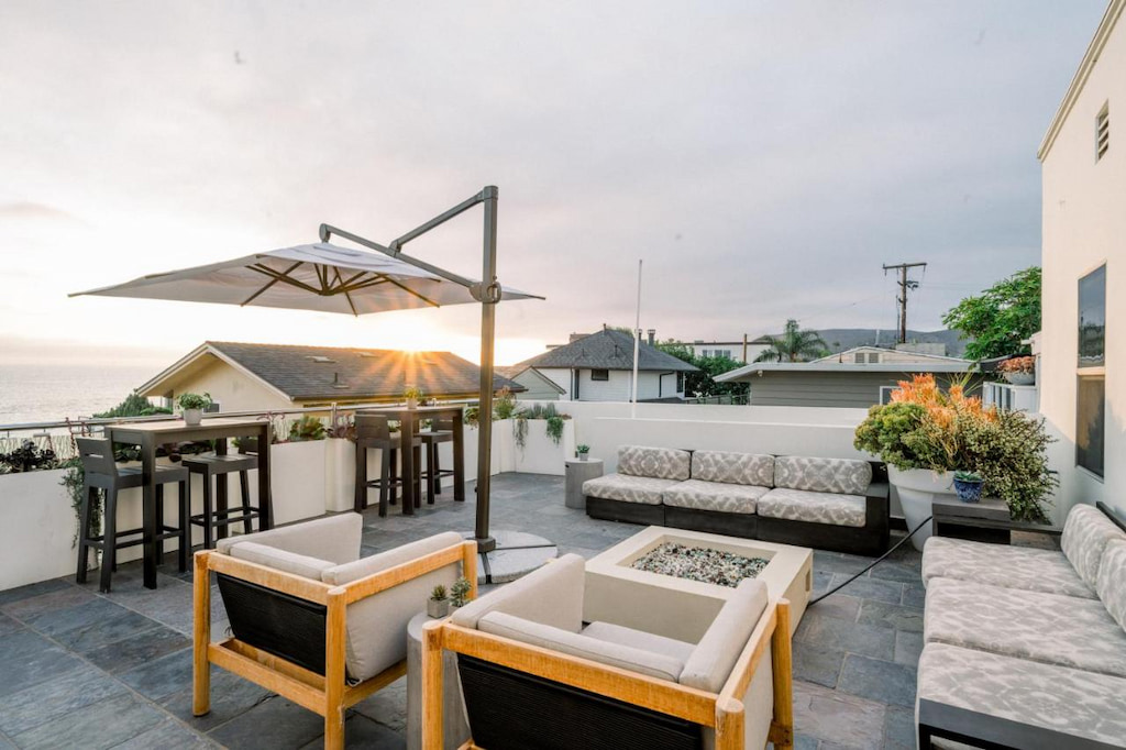 Laguna Beach design hotel balcony with an outdoor sofa and modern fire pit during sunset