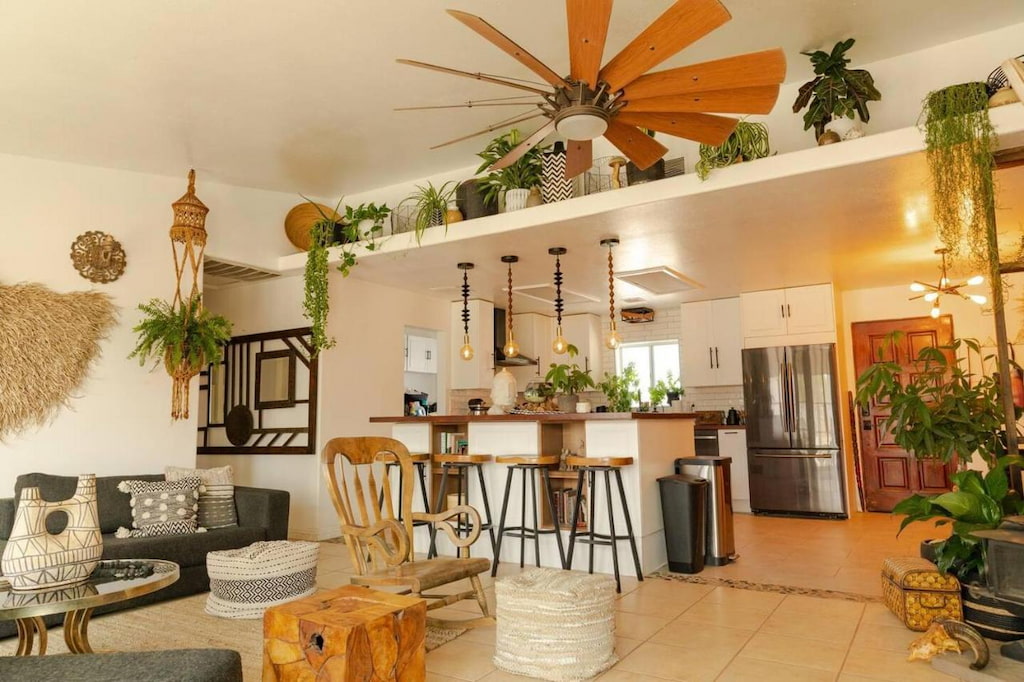 eclectic hotel room featuring wood and green plant accents and a kitchen bar counter with a ceiling fan above