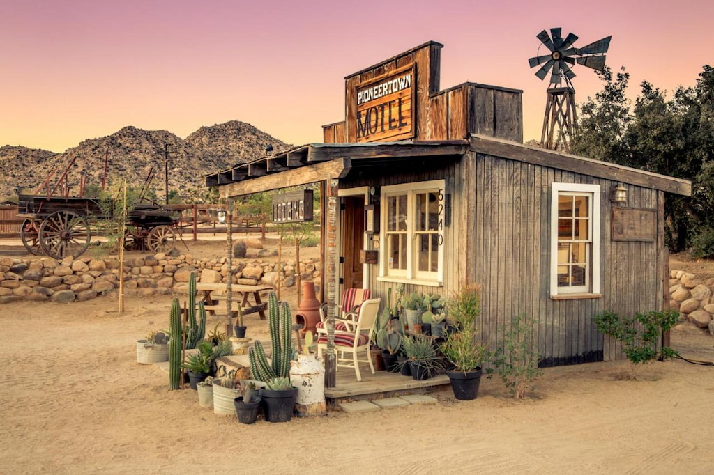 historic Pioneertown Motel front-desk surrounded by cacti on a pink sunset evening