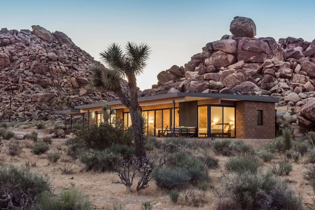best hotel in Joshua tree surrounded by huge mountain rocks and cacti at sunset