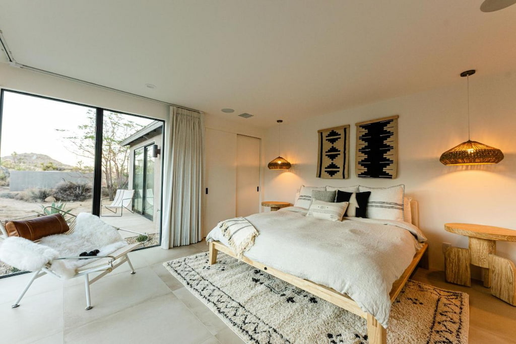 all-white room with a king-size bed with white blanket near the window