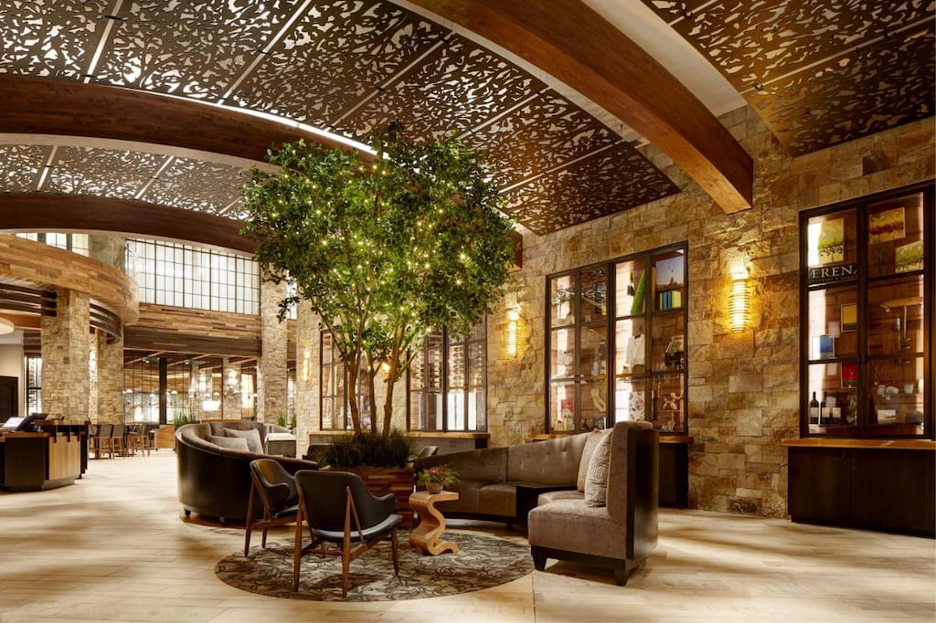 lounge area of the hotel with rustic design and a live small tree in the middle.