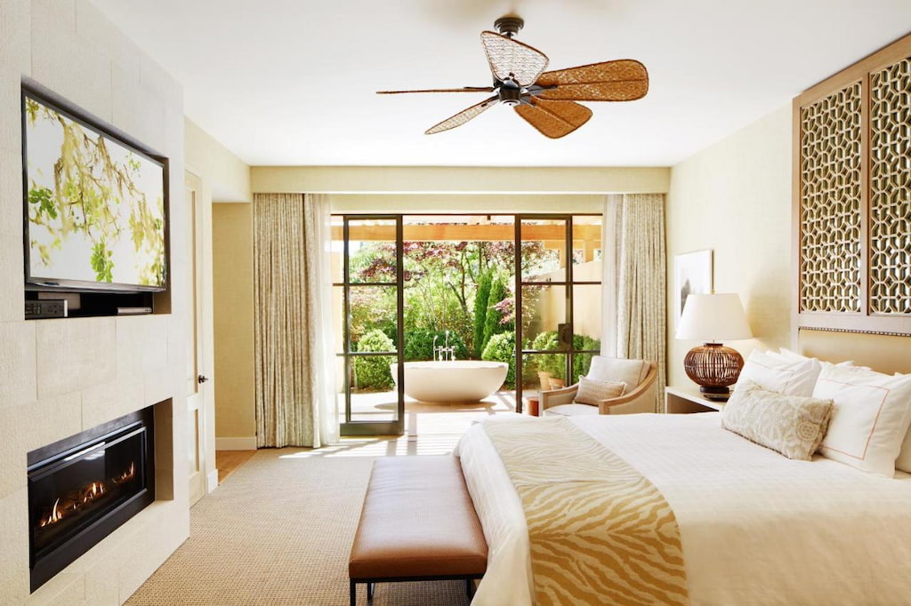 a minimalist room in one of the hotels in Napa with a ceiling fan above the bed in front of the TV