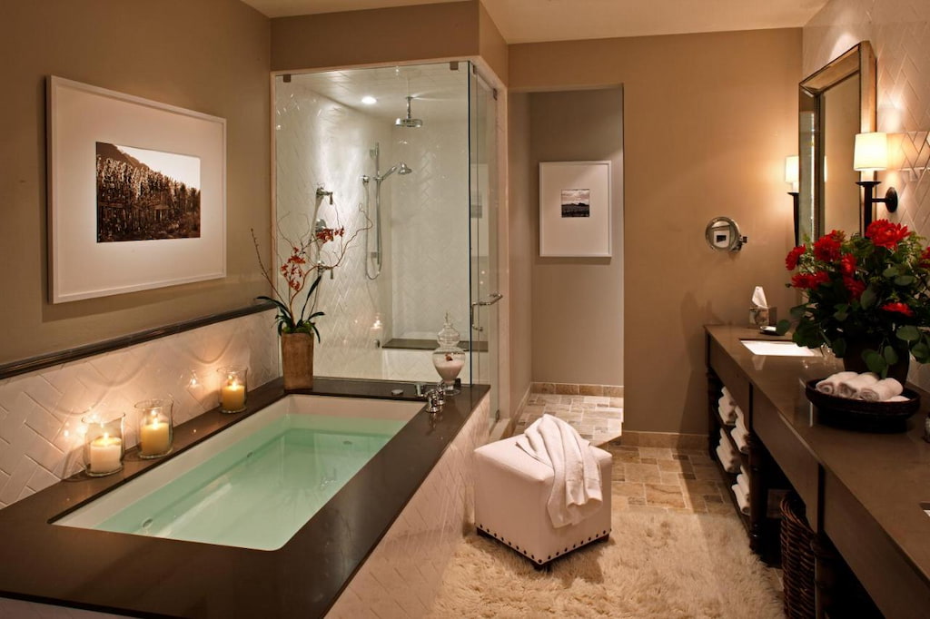 elegant tub and a shower area with glass walls near the vanity mirror.