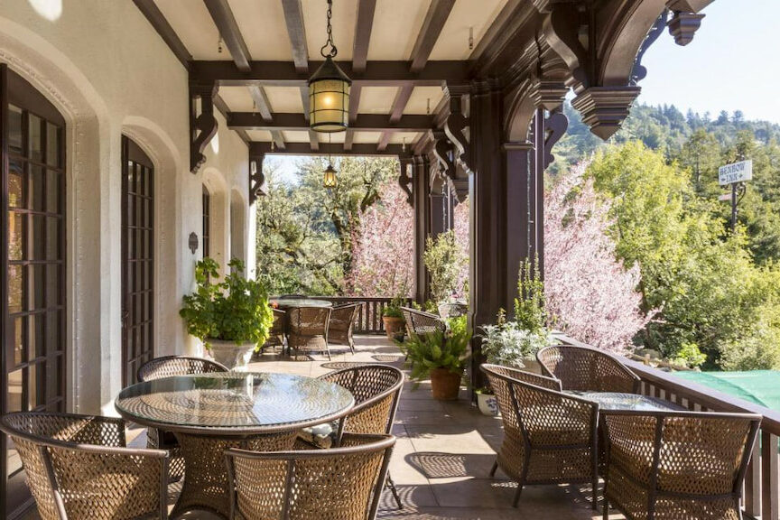historic hotel in Northern CA manor patio with brown wicker tables and chairs with foliage in the distance