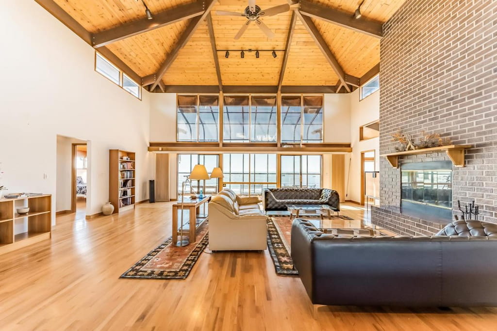 luxury house rental in Northern California with wooden peaked ceiling with fan above the living room with a modern brick fireplace
