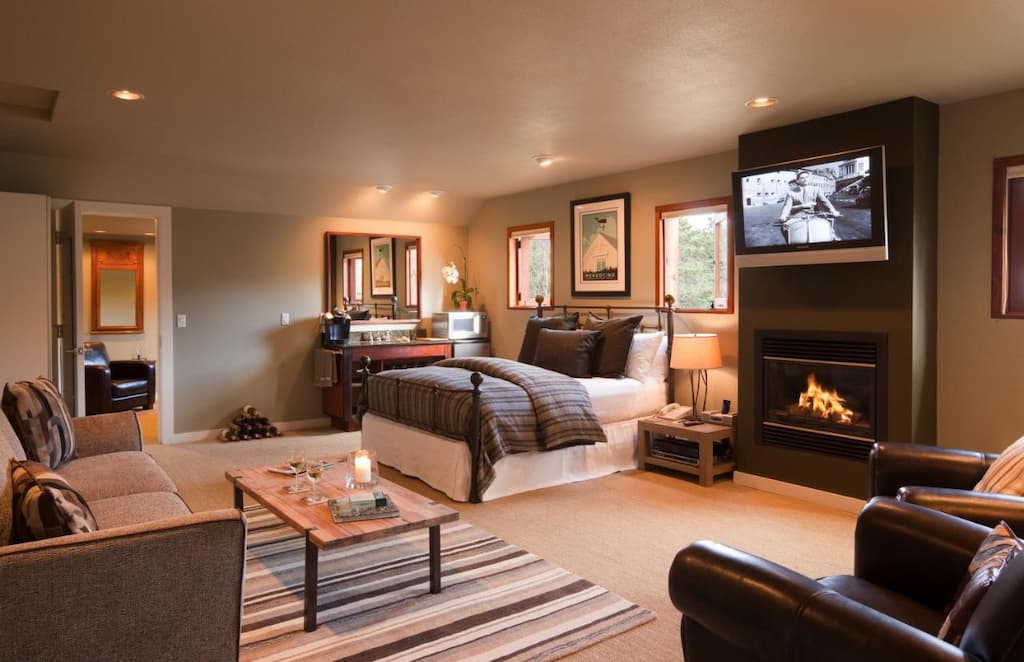 a luxury hotel room with a fireplace below the installed TV near the bed