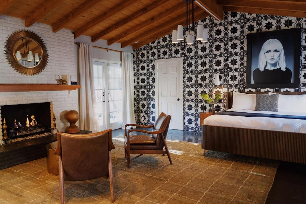 black and white tiled feature wall with art over a bed and cozy fireplace at one of the best Palm Springs boutique hotels
