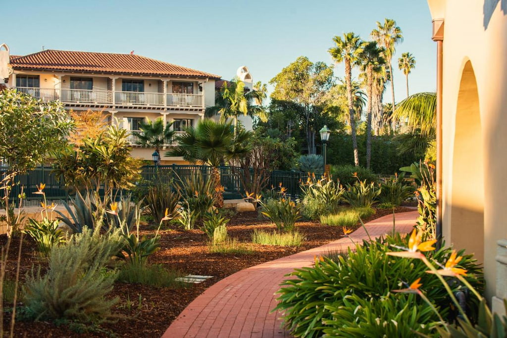 A luxurious Santa Barbara holiday home surrounded by trees and plants and a small pathway.