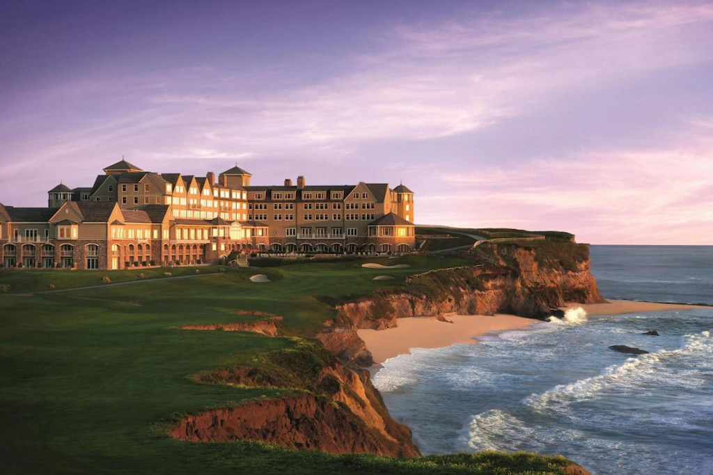 Coastal panoramic of a boutique hotel in Half Moon Bay California near a cliff and the shore during sunset
